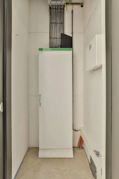 部屋の隅にある白い冷蔵庫の冷凍庫を改造して保管する準備ができています — ストック写真