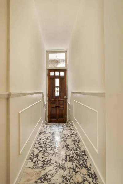 Długi Korytarz Marmurową Podłogą Białym Wykończeniem Ścian Prowadzącym Otwartych Drzwi — Zdjęcie stockowe