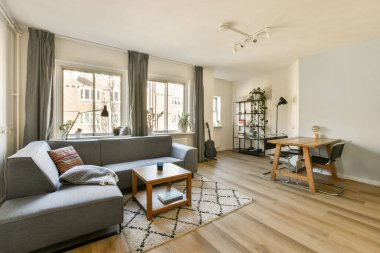 Odanın köşesinde kanepesi, sehpası ve televizyonu olan bir oturma odası çok temiz.