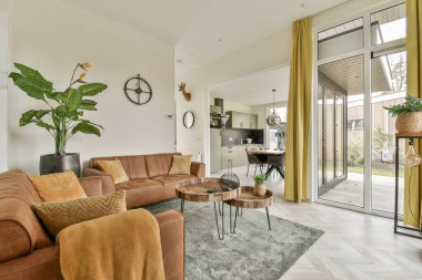 Odanın ortasında kanepeleri, kahve masası ve büyük bitkileri olan bir oturma odası açık bir avludur.