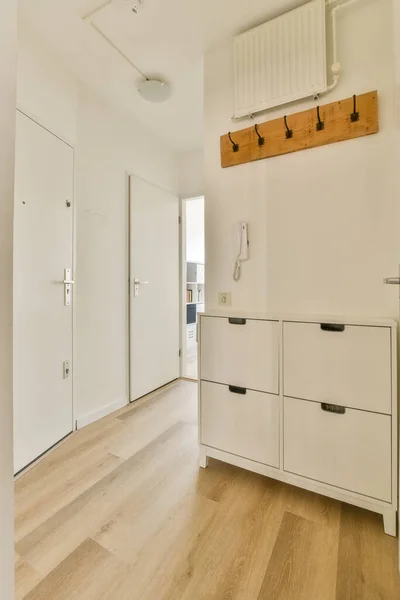 an empty kitchen with white cupboards and drawers on the wall behind it is a wood floor that has been used for storage