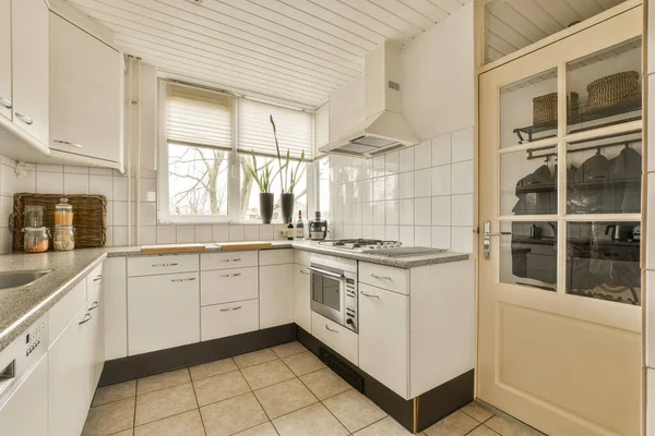 Lavabonun Önündeki Tezgahların Üzerinde Beyaz Dolaplar Siyah Tezgahlı Bir Mutfak — Stok fotoğraf