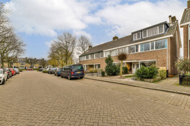 Yan tarafında arabalar, arka tarafında evler olan bir cadde. Hepsi birbirine bakıyor.