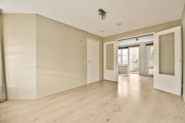 Odasında ahşap döşeme ve beyaz duvarlar olan boş bir oturma odası çok temiz, ama ışık yok.