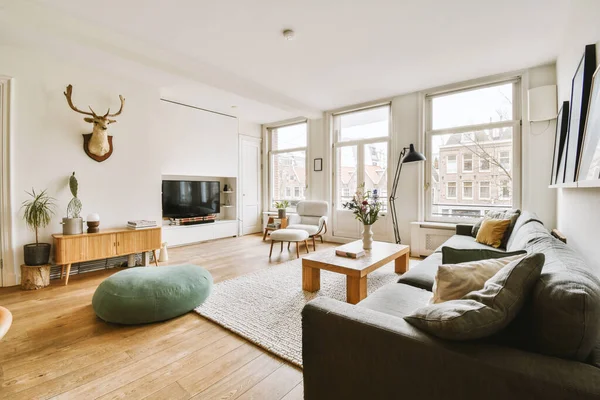 Stock image a living room with couches, coffee table, and television on the wall in the room is bright white