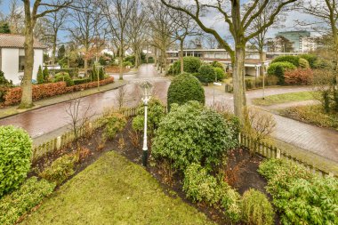 Ön tarafında ağaçlar ve çalılar olan bir yerleşim yeri. Güneşli bir günde havadan görüntü alındı.