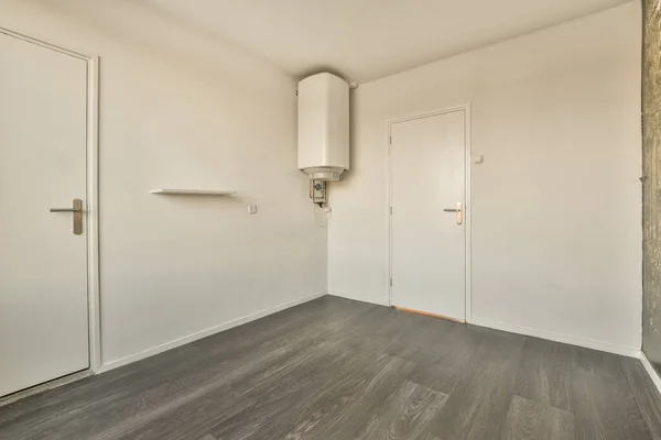 stock image an empty room with wood floors and white doors on either side, there is no one person in the room