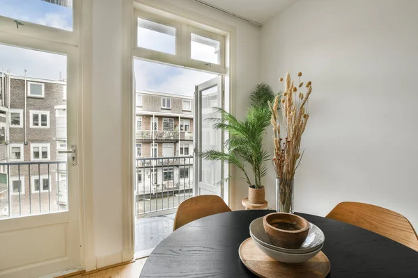 stock image a dining table and chairs in a room with large windows looking out onto the cityscaped view outside