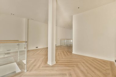 an empty room with white walls and wood flooring on the right, there is a mirror in the corner