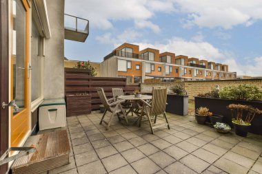 tuğlalı evlerin önünde yerde bitki ve çömlek olan bir alan.