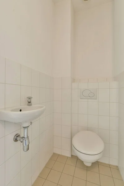 Duvarlarında Beyaz Fayanslar Olan Bir Banyo Lavabonun Yanındaki Klozet — Stok fotoğraf