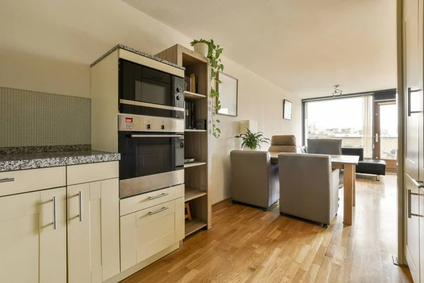 Uma Cozinha Sala Estar Apartamento Com Piso Madeira Armários Brancos — Fotografia de Stock