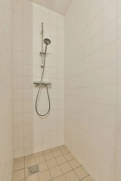 Duş Başlıklı Beyaz Fayanslı Bir Banyo Duvardaki Parmaklıklar Yerdeki Seramik — Stok fotoğraf