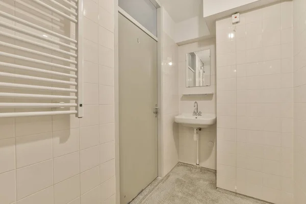 壁や床に白いタイルの小さなバスルームと部屋の中央にあるトイレ — ストック写真