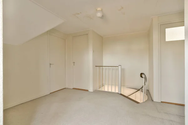 Uma Sala Vazia Com Paredes Brancas Carpete Chão Uma Escada — Fotografia de Stock