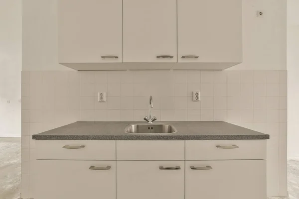 Eine Küche Mit Weißen Schränken Und Grauen Arbeitsplatten Auf Den — Stockfoto