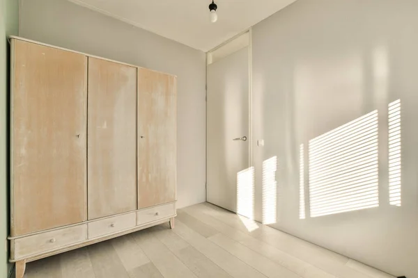 Beyaz Duvarları Yerde Hafif Ahşap Mobilyaları Olan Bir Yatak Odası — Stok fotoğraf