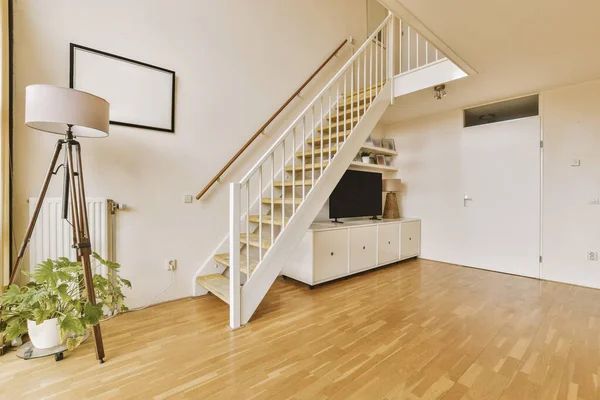 Uma Sala Estar Com Piso Madeira Escada Pintada Branco Que — Fotografia de Stock