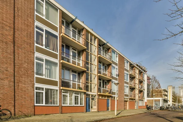 stock image a brick building with many windows and bales on the sides, along a street lined with parked bicycles in front