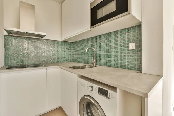 a laundry room with a washer, dryer and dishwasher on the counter in front of the sink