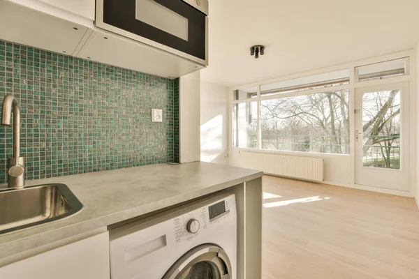 a laundry room with a washer and dryer on the floor in front of an open doored window