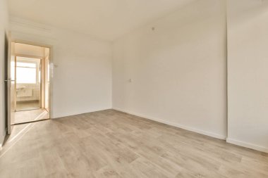 Beyaz duvarları ve ahşap döşemeleri olan boş bir oda. Odanın sağ tarafı açık.