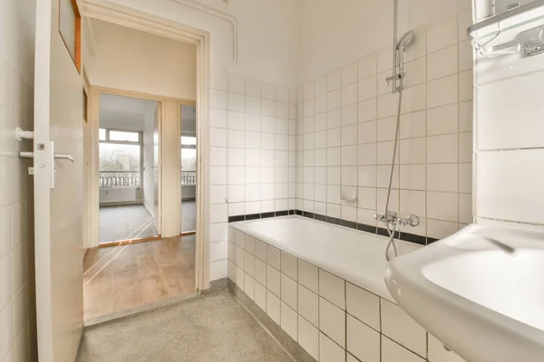 壁に白いタイルのバスルームと部屋の反対側の隅にある大きな鏡 — ストック写真