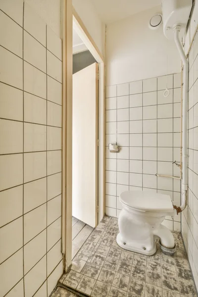 床や壁に白いタイルのバスルーム部屋の中央にトイレを含む — ストック写真