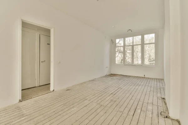 白い壁と木の床が両側にある空の部屋左側のドアがあります — ストック写真