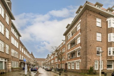 Kenarında arabaları olan bir şehir caddesi ve caddenin ortasında yürüyen insanlar.