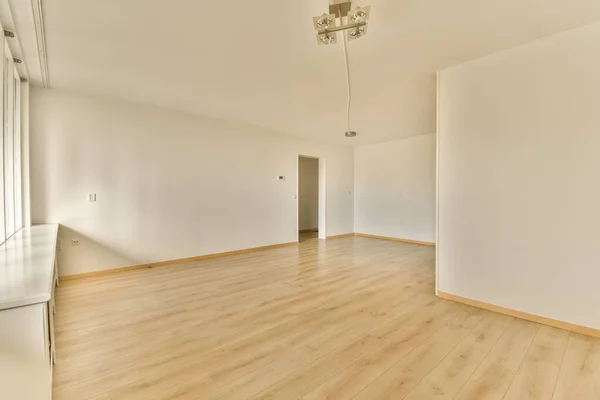 右側に白い壁と木の床がある空の部屋角に鏡があります — ストック写真