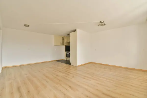部屋には木の床と白い壁がある空のリビングルームはとても清潔で使いやすいです — ストック写真