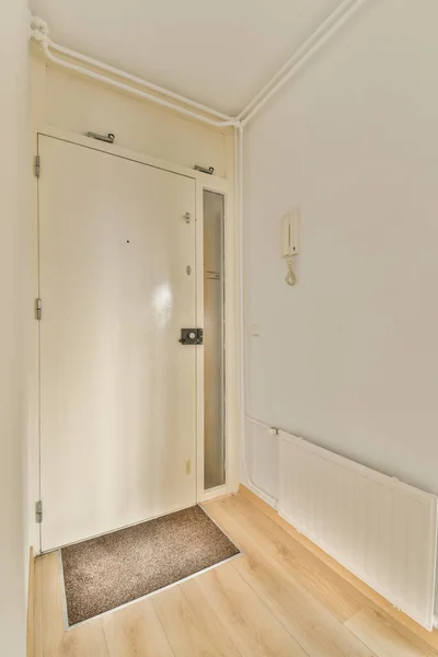 白い壁と木の床のある空いている部屋の右側にドアが開いています — ストック写真