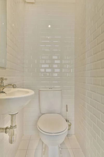 壁や床に白いタイルの小さなバスルームと部屋の中央にあるトイレ — ストック写真