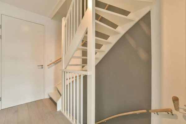 灰色の壁と堅木の床の家の白い階段階段は木の板で作られています — ストック写真
