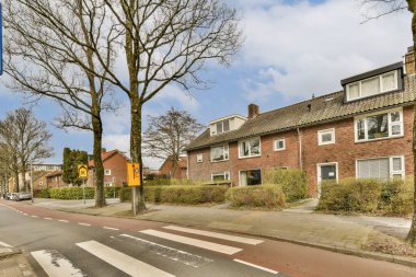 Arabası ya da yolda insanları olmayan boş bir cadde ve fotoğraftaki bazı evler sokağın karşısından çekiliyor.