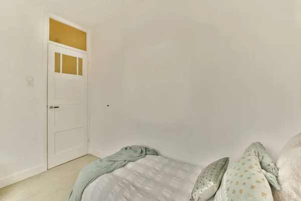 白い壁とベージュのカーペット敷きの床がある寝室の左側にはドアが開いています — ストック写真