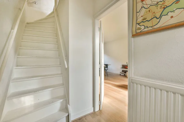 a white staircase in a room with hardwood flooring and walls painted off to make it look like an open space