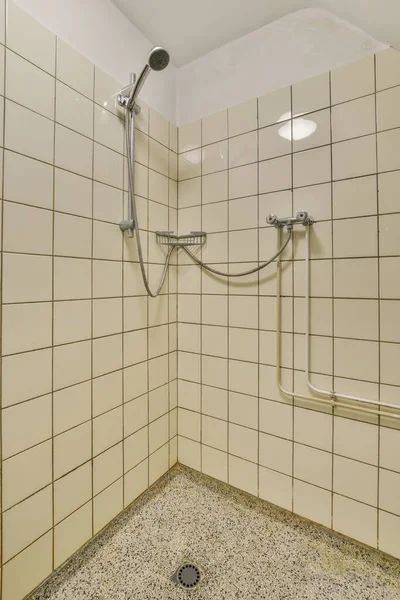 壁に黒と白のタイル張りのタイル張りの浴室に金属製の手すりがあります — ストック写真