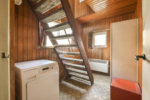 stock image a laundry room with wood paneled walls and white washer in the corner, next to a washing machine