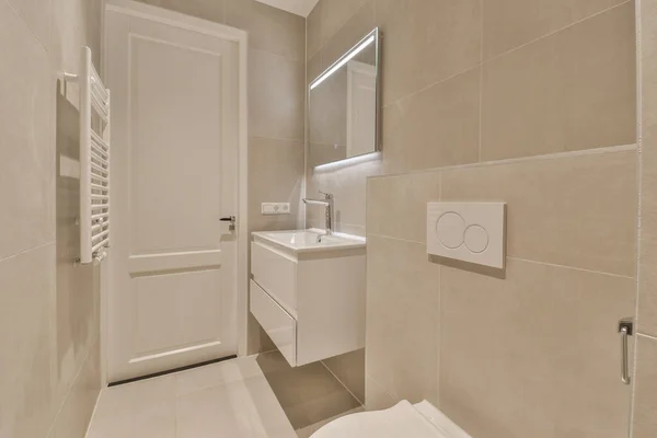 Ein kleines Bad mit weißen Fliesen und grünen Zierleisten an den Wänden, es  gibt einen Spiegel über dem Waschbecken Stockfotografie - Alamy