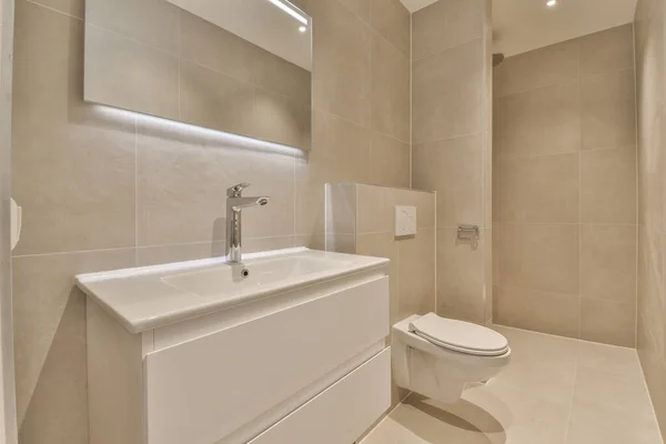 Koupelna Béžovými Dlaždicovými Stěnami Bílými Dlaždicemi Stěně Vedle Umyvadla Toaleta — Stock fotografie