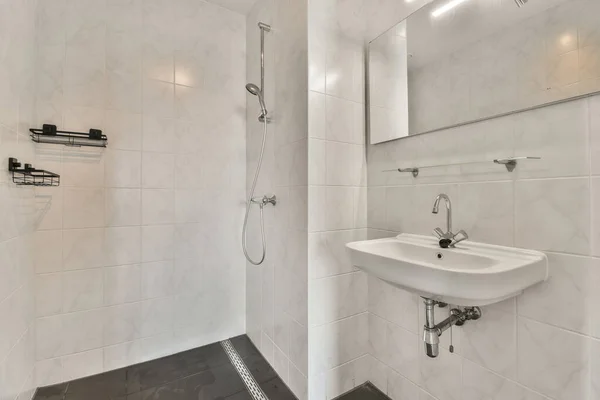 Łazienka Białymi Ścianami Czarną Podłogą Tym Umywalka Głowica Prysznicowa Zamontowane — Zdjęcie stockowe