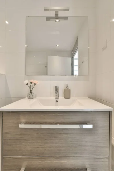 洗面台の前のカウンターの上に洗面台と鏡があるバスルームは壁の白いタイルです — ストック写真