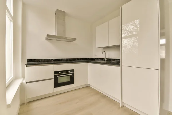 stock image a kitchen with white cabinets and black counter tops on the counters in front of the oven, which is mounted into the wall