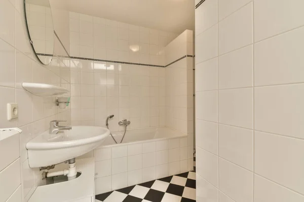 바닥에 흰색의 체크무늬 타일이 샤워실에 싱크대와 — 스톡 사진