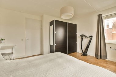 Banyo kapısının önündeki duvarda yatak odası, masa ve ayna var.