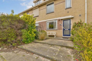 Ön bahçesinde çalılar ve çalılar olan bir evin dış görüntüsü ön bahçeden alınmıştır.