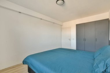 Yatağın önündeki duvarda yatak odası ve dolaplar arkasında boş bir dolap var.