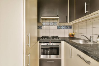 Fırını, lavabosu ve bulaşık makinesi olan bir mutfak odanın kapısının önünde.